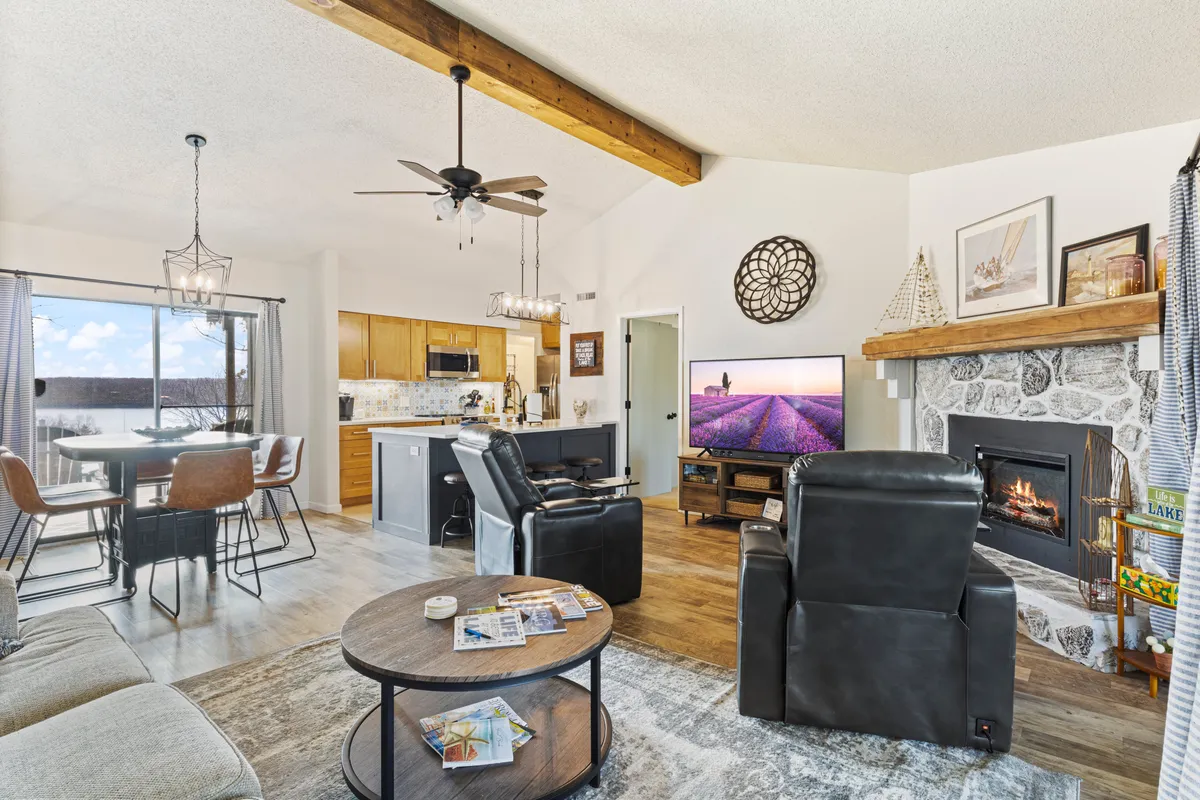A comfortable living and dining area with a fireplace, TV, elegant dining table, and a well-arranged seating area. The layout encourages both socializing and quiet moments, with a warm and welcoming ambiance.
