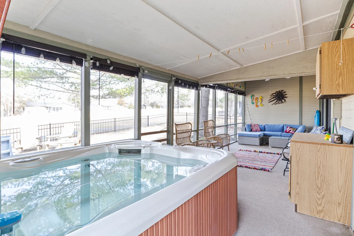 A cozy indoor hot tub space with adjacent seating and tasteful decorative wall art. The area is designed for relaxation and socializing, with soft lighting and a welcoming ambiance, ideal for post-golf rejuvenation with friends.